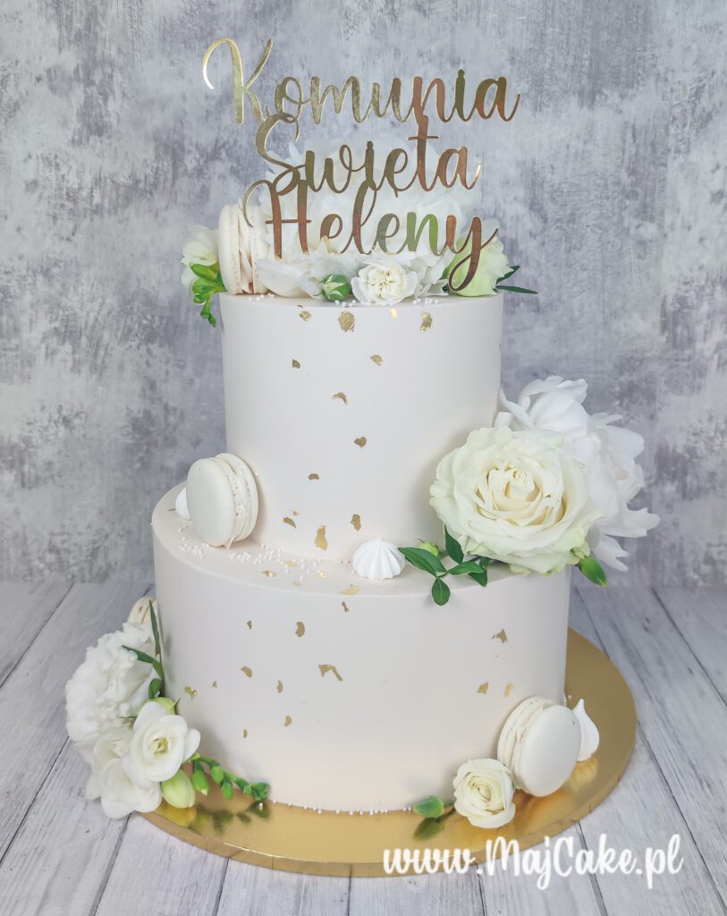 Tort komunijny dwupiętrowy z białymi kwiatami i złotym topperem